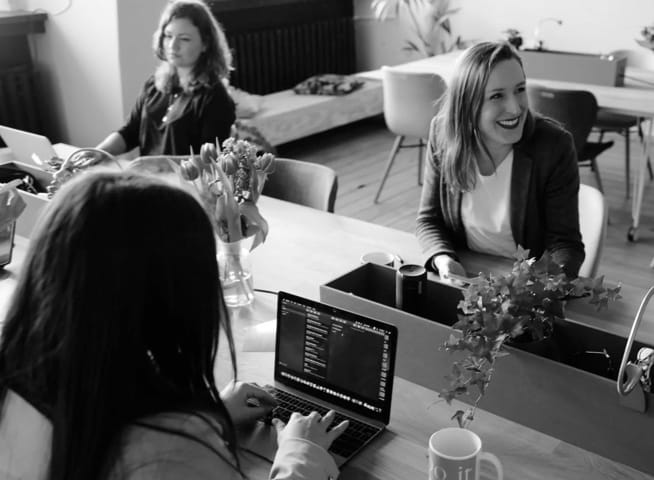 two women sitting at desk and working together